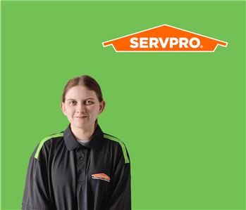 SERVPRO employee with dark hair wearing a black shirt in front of a green background