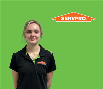 SERVPRO® employee with light hair wearing a black shirt in front of a green background